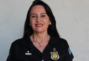 Mulher sorrindo vestida de uniforme 